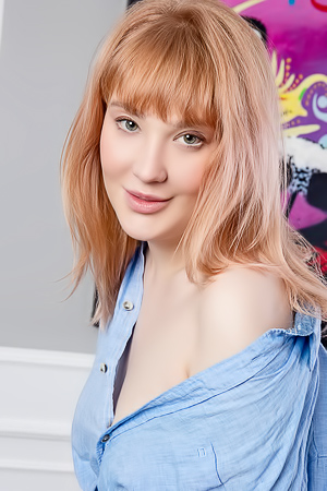 Emily Blakes legs spread wide over the wooden chair